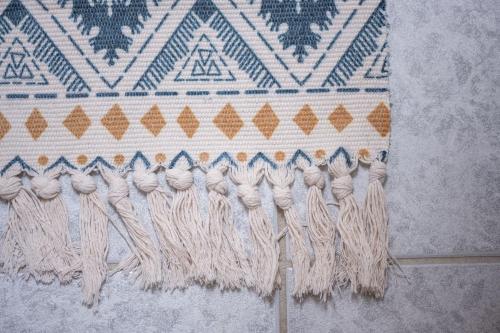 a rug with fringe on a wall at Ferienwohnung Pop s Huus 35226 in Holtland