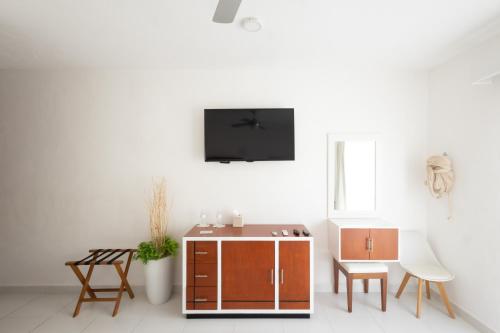 a living room with a tv on a white wall at Saastah Hotel Boutique in Valladolid