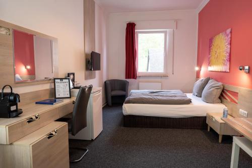 a hotel room with a bed and a desk at Honeybee Properties Mosel in Winningen