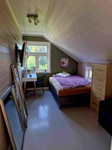 a bedroom with a bed and a table and a window at Kræmarvika Vila in Tromsø