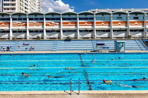 une grande piscine avec des gens qui nagent dedans dans l'établissement Charmant Studio Climatisé au Mourillon, à Toulon
