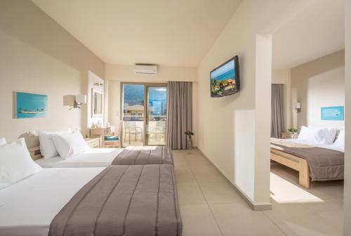 a hotel room with two beds and a tv at Malliotakis Beach Hotel "by Checkin" in Stalida