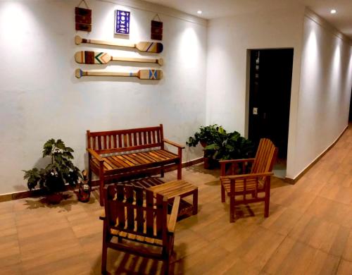 a room with two chairs and a bench and a shelf at Pousada Só Lazer in Touros