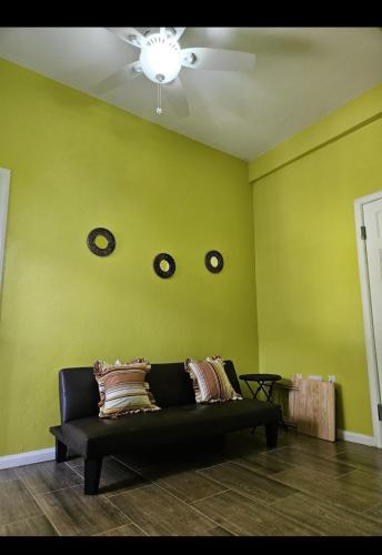 a living room with a couch and clocks on the wall at La Bwizan Apt # 2 in Laborie