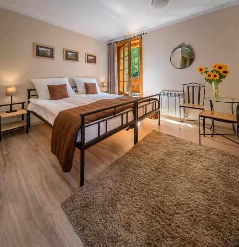 a bedroom with a large bed and a table at Willa Orle Gniazdo in Biała Woda