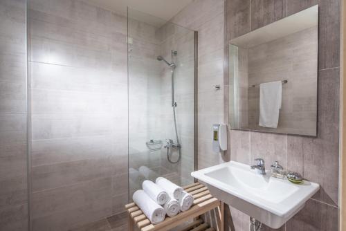 y baño con lavabo y ducha. en Malliotakis Beach Hotel "by Checkin", en Stalida
