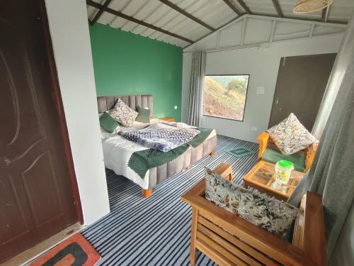 a bedroom with a bed and a couch in a room at Neo Resort in Kanatal