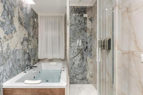 a bathroom with a tub and a shower and a sink at Le stanze di Venere in Naples