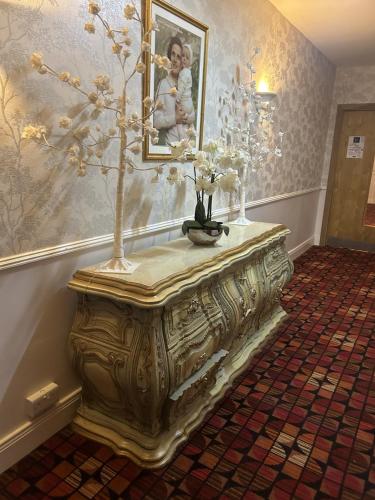 a table with flowers on it in a room at Drummond Hotel in Ballykelly