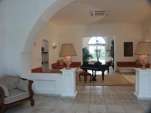 a living room with a piano and a chair at Golf Club Metaponto in Metaponto