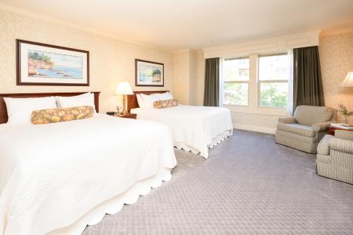 a hotel room with two beds and a chair at Fairhaven Village Inn in Bellingham