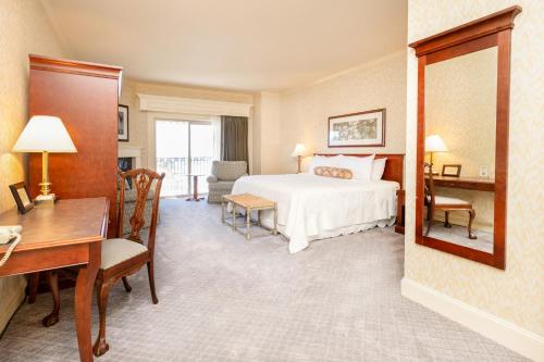 a bedroom with a bed and a desk and a table at Fairhaven Village Inn in Bellingham