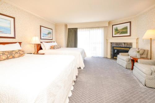 a hotel room with two beds and a fireplace at Fairhaven Village Inn in Bellingham