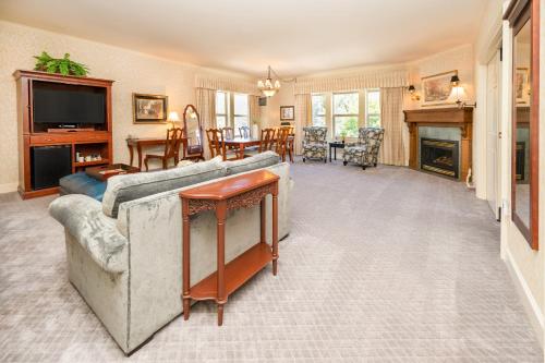 a living room with a large couch and a television at Fairhaven Village Inn in Bellingham