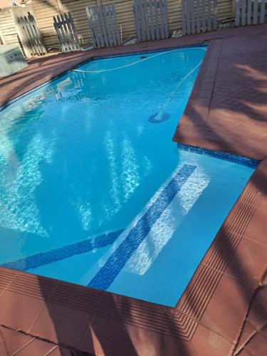 an empty swimming pool with blue water at Randhart guesthouse in Alberton