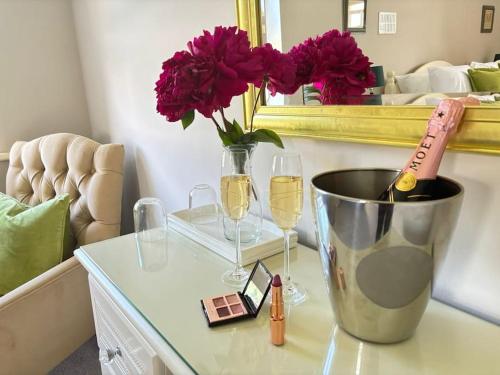 a table with a vase of flowers and wine glasses at Ladyrath Lodge in Navan