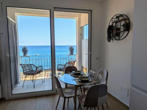a dining room with a table and a view of the ocean at Alema apartment Giardini Naxos in Giardini Naxos