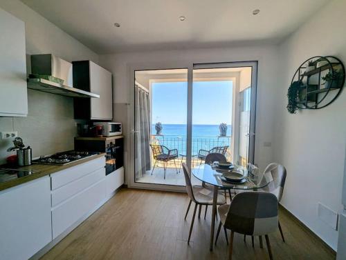 a kitchen with a table and a view of the ocean at Alema apartment Giardini Naxos in Giardini Naxos
