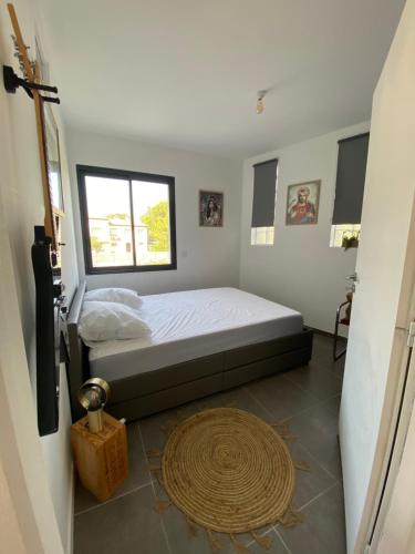 une chambre avec un lit et une grande fenêtre dans l'établissement Appartement - Le Seven, à Uzès