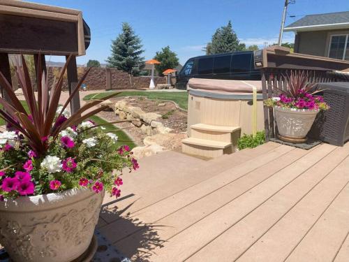 a wooden deck with some flowers and a bench at Tacit Shadow Resort Aviator Queen Suite, Gym, Coffee Bar, Hot-Tub, Free Laundry, Food Available in Parowan