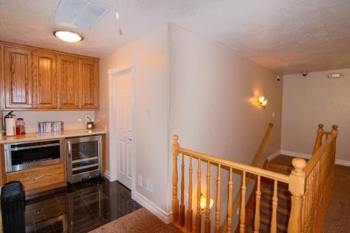 a kitchen with wooden cabinets and a staircase in a house at Tacit Shadow Resort Aviator Queen Suite, Gym, Coffee Bar, Hot-Tub, Free Laundry, Food Available in Parowan