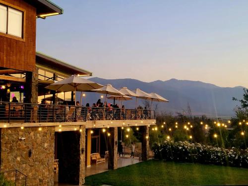 a restaurant with tables and umbrellas on a patio at Olmue Natura Lodge & Spa in Olmué