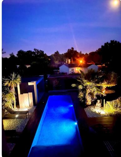 a house with a swimming pool at night at Villa du lac in Arsac
