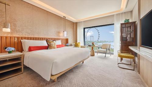 a bedroom with a large white bed and a large window at Mandarin Oriental, Singapore in Singapore
