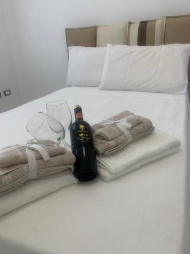 a bed with towels and a bottle of wine and glasses at B&B Passione Salento in Surbo