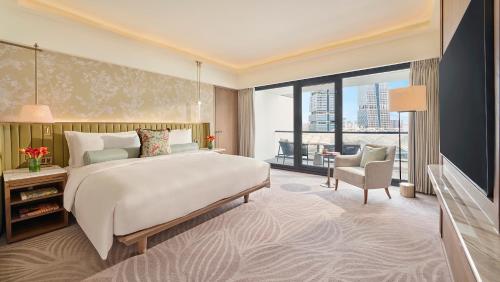 a bedroom with a large bed and a large window at Mandarin Oriental, Singapore in Singapore