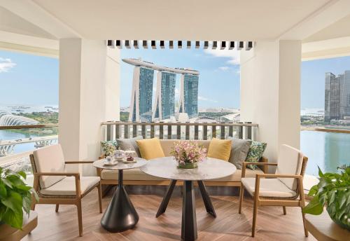 a living room with a couch and a table with chairs at Mandarin Oriental, Singapore in Singapore