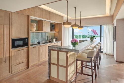 a kitchen with a large island with bar stools at Mandarin Oriental, Singapore in Singapore