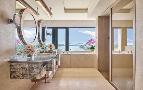 a bathroom with a large mirror and a sink at Mandarin Oriental, Singapore in Singapore