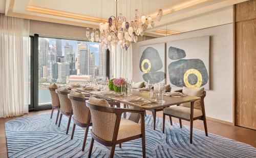 a dining room with a long table and chairs at Mandarin Oriental, Singapore in Singapore