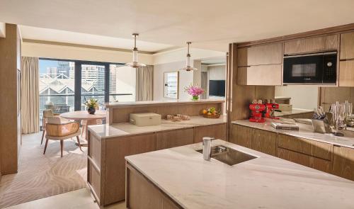 a kitchen with wooden cabinets and a dining room at Mandarin Oriental, Singapore in Singapore