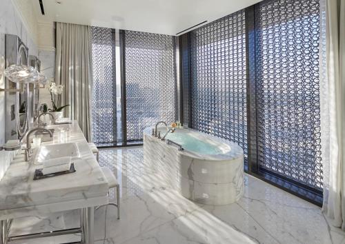 a bathroom with a tub and a large window at Mandarin Oriental, Doha in Doha