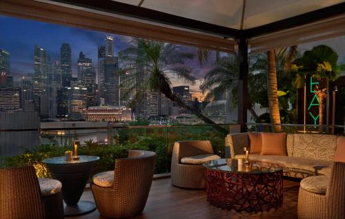 a patio with chairs and tables and a view of a city at Mandarin Oriental, Singapore in Singapore