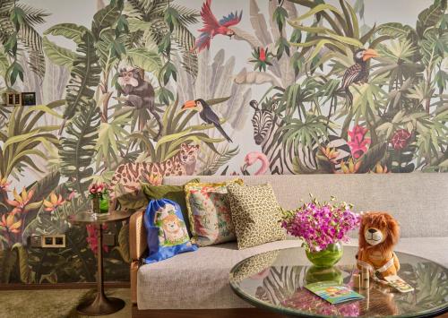 a living room with a couch and a table with flowers at Mandarin Oriental, Singapore in Singapore