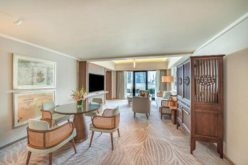 a living room with a table and chairs at Mandarin Oriental, Singapore in Singapore