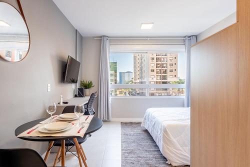 a hotel room with a bed and a table with wine glasses at Connect by LikeHome in Porto Alegre