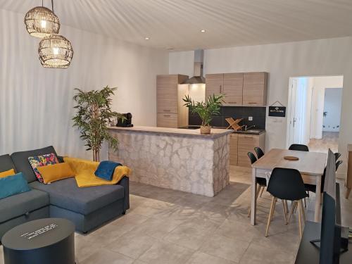 un salon avec un canapé et une table et une cuisine dans l'établissement Appartement Le Tranquille centre ville Rouen, à Rouen
