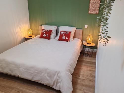 - une chambre avec un lit blanc et 2 oreillers rouges dans l'établissement Appartement Le Tranquille centre ville Rouen, à Rouen