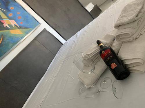 a bottle of wine and glasses on a table at B&B Passione Salento in Surbo