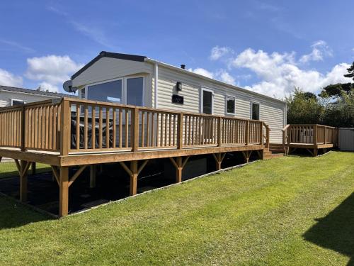 a mobile home with a deck and a yard at Seagulls Rest in Newport