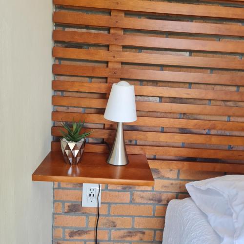 a lamp on a table next to a brick wall at Habitaciones San Marcos 3 in Tequila