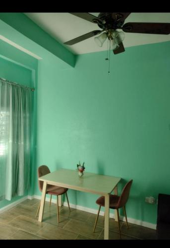 a dining room table with chairs and a ceiling fan at La Bwizan Apt #3 in Laborie