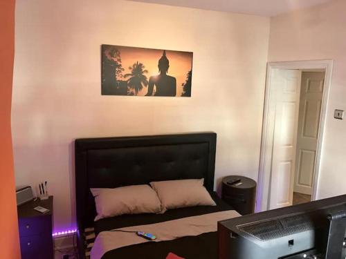 曼彻斯特King TV-Bed En-suite MediaCity, MUFC, Salford的卧室里有一张床，墙上挂着一幅画