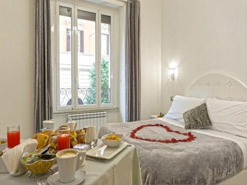 Un dormitorio con una cama y una mesa con comida. en Vatican Grand Suite, en Roma