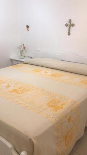 a bed with a cross on top of it at APPARTAMENTO LIDO 1 in Alghero