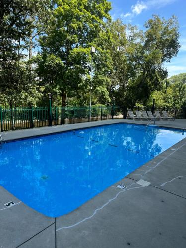 a blue swimming pool with trees in the background at River Place Condos #101 2BD in Pigeon Forge